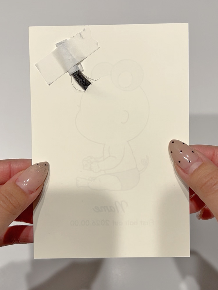 髪の毛の位置を整えて裏面をテープで固定している工程